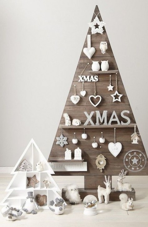 a plywood Christmas tree with shelves with white figurines and ornaments is rustic meets modern