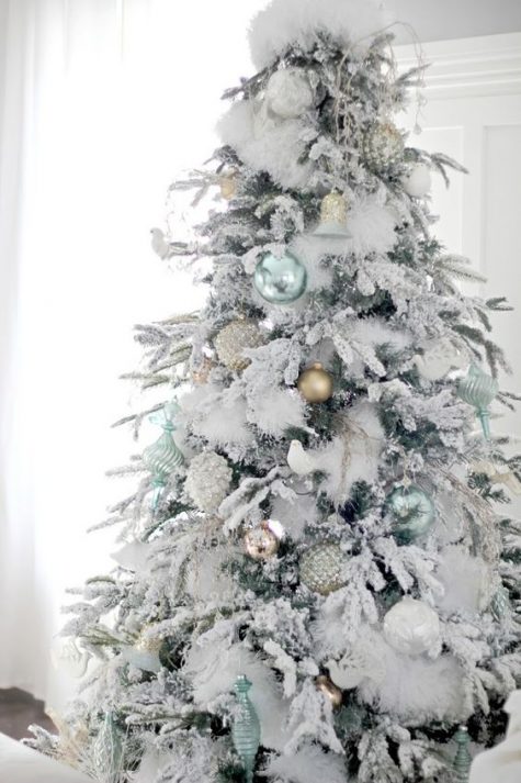 light green and matte gold ornaments look very fresh on a flocked Christmas tree and feel very natural and cool