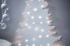 25 a white Christmas tree silhouette wall art with lights is great for a minimalist space or a Nordic one