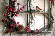 a Christmas decoration instead of a usual wreath – a brnch frame with twigs, berries, moss and pinecones