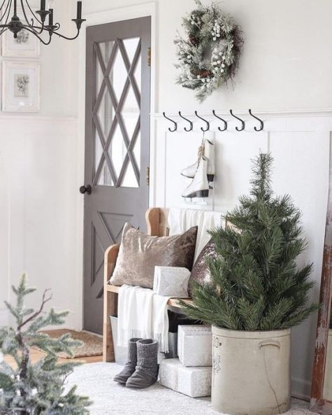 a Christmas tree, some velvet pillows, a snowy Christmas wreath with berries for a neutral holiday entryway