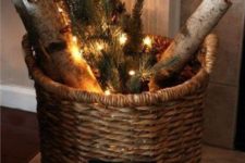 a basket with evergreens, firewood and lights can act as a Christmas decoration itself