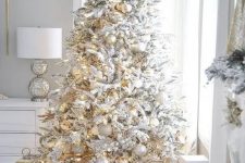 a beautiful flocked Christmas tree with white and metallic ornaments is always a very cool idea for a winter wonderland feel