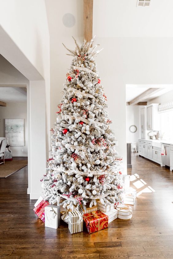 a chic Christmas tree with red and white ornaments, ribbons and branches on top is a cool decor idea for the holidays