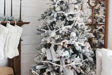 a flocked Christmas tree decorated with white ornaments, lights, stars and garlands is a super cool and catchy idea