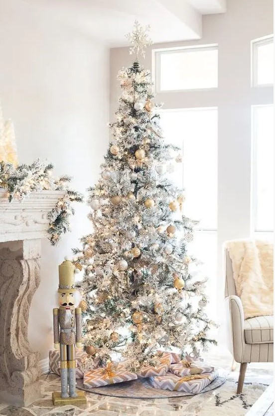 a flocked Christmas tree with a snowflake topper pastel and yellow and silver ornaments looks refined