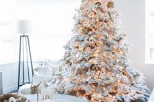 a flocked Christmas tree with matching white and silver ornaments and lights is a gorgeous idea for Christmas