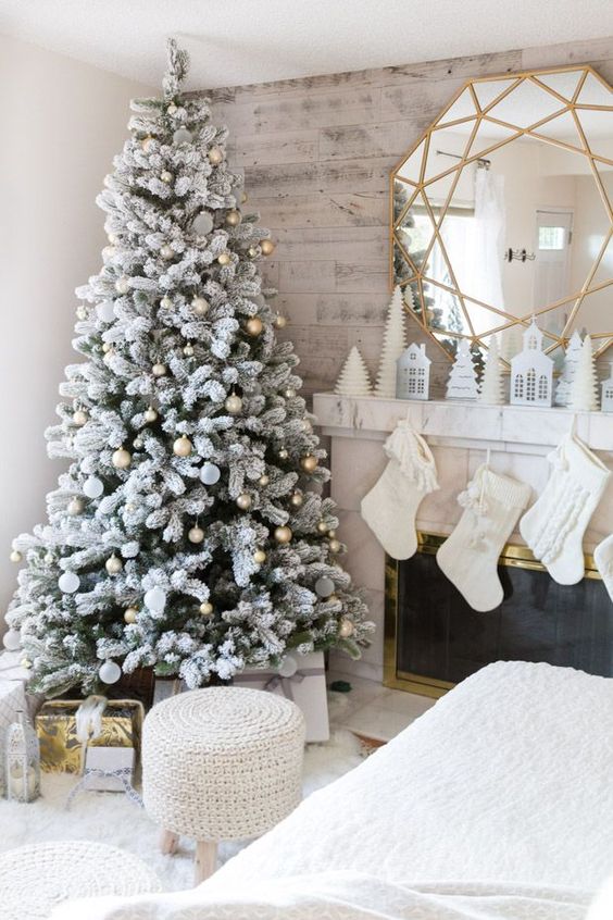 a flocked Christmas tree with metallic ornaments is a super glam and cool idea, it looks shiny, cool and catchy
