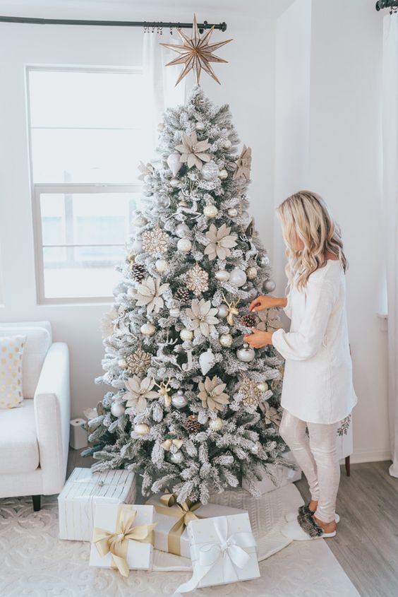 a flocked Christmas tree with oversized fabric flowers, pinecones and ornaments is a cool and super glam idea to rock