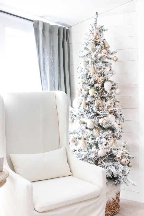 a flocked Christmas tree with oversized metallic ornaments, lights and bells is a lovely glam decor idea for the holidays