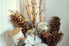 a galvanized bathtub with firewood, large pinecones, a poinsettia flower, lights and ornaments is a Christmas decoration for any space