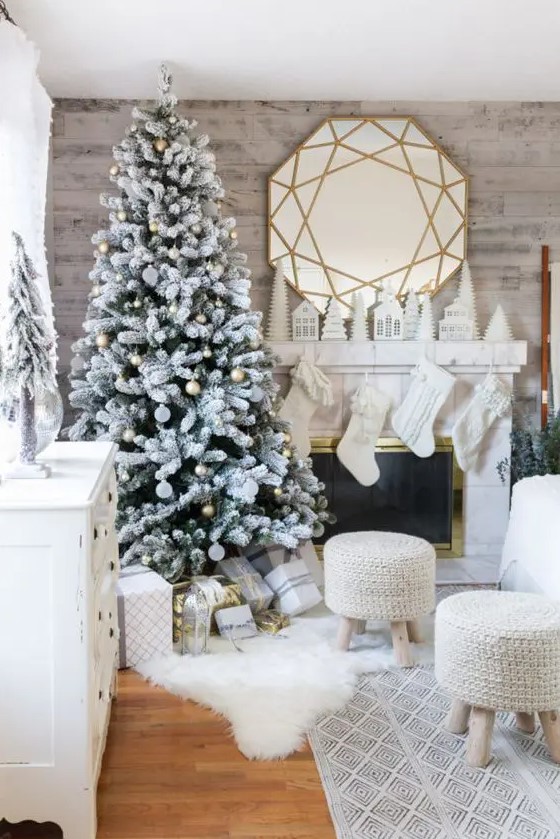 a modern flocked Christmas tree with white and gold ornaments is a chic idea that brings ultimate elegance