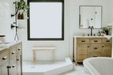 a modern neutral bathroom with hex and subway tiles, wooden vanities and touches of black for drama