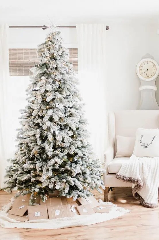 a perfect flocked Christmas tree with oly lights and nothing else is a gorgeous idea for a winter wonderland Christmas party