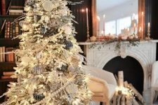 a refined winter wonderland Christmas tree with black, silver and white ornaments, beads, lights and a star tree topper is a gorgeous statement
