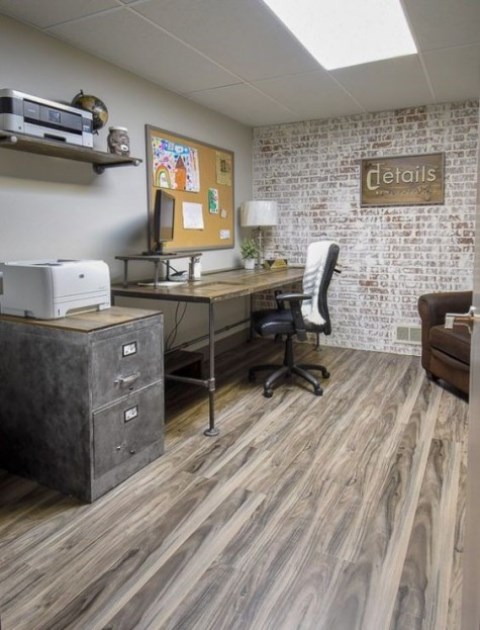 a simple rustic industrial home office with a desk that changes height, leather chairs, a metal cabinet