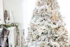 a white Christmas tree with shiny metallic ornaments, luffs, stars and flowers plus a star topper