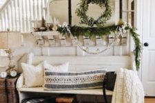 cozy knit pillows and a blanket, an evergreen garland and wreath will create a Christmas feel