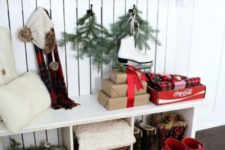 evergreens and Christmas trees in buckets, firewood, red boots, lights, gift boxes and plaid pillows for a Christmas feel