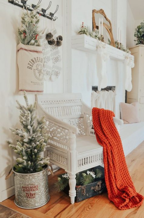 snowy evergreen decor, pinecones, berries, neutral stockings and pillows and a red blanket for a Christmas feel