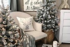 two flocked Christmas trees with lights placed into baskets are nice for a cozy farmhouse feel in the space