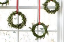 02 evergreen wreaths with red ribbons to decorate the window is a cool holiday look, a fresh take on traditional decor
