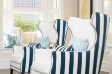 06 bold nautical wingback chairs with creamy fronts and striped backs plus decorative nail trim for a coastal interior