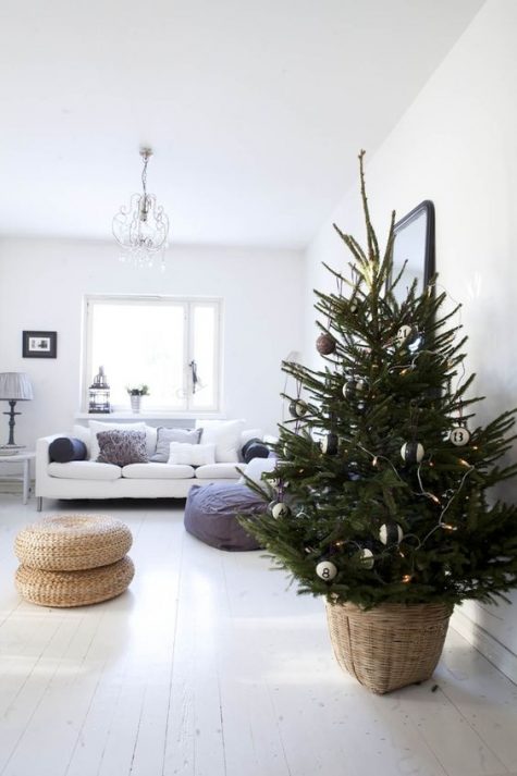 a minimalist Christmas tree with black and white ornaments and lights in a basket looks very natural and bold