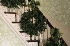 07  a trio of evergreen wreaths with green ribbons to decorate the stairs and give a slight vintage feel to the space