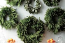 08 an arrangement of evergreen wreaths over the fireplace made if various types of greenery and evergreens is super chic