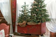 09 a vintage red sleigh with a Christmas tree duo with lights looks very cozy and brings a rustic feel