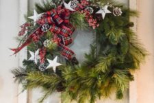 09 a whimsy evergreen wreath with plaid ribbons, stars and snowy pinecones plus a matching garland on the mantel for holidays