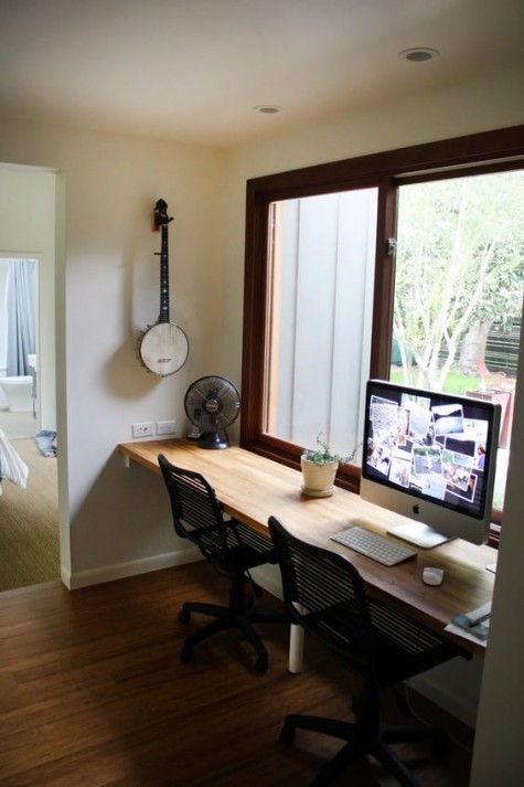 a windowsill floating desk and a couple of chairs make up a comfortable nook for work with plenty of natural light