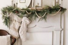 13 a neutral vintage Christmas nook with a beaded garland, evergreens and pinecones plus vintage frames brings a rustic feel, too