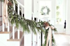 15 a lush evergreen garland with eucalyptus, pinecones and striped ribbon bows is a nice farmhouse-like decoration