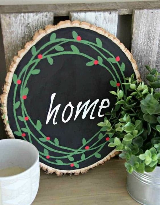 a painted Christmas sign with chalkboard paint, bright green and red decor and a chalk word for a cozy rustic feel