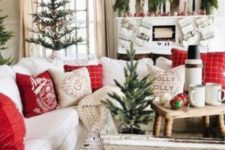 17 a vintage farmhouse Christmas living room with mini trees, red ornaments, red and white pillows and stockings