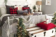 19 a vintage rustic Christmas bedroom with mini lit up trees, crochet blankets and plaid pillows, evergreens