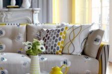 21 a bright sofa with a yellow striped base and neutral cushions and pillows with a fruit print is a fun and quirky idea to go for
