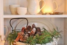 21 a vintage soup bowl with evergreens and pinecones is a nice Christmas centerpiece with a refined feel