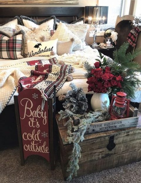 vintage Christmas bedroom decor with snowy evergreens, red roses, a vintage sleigh and cozy knit and crochet blankets