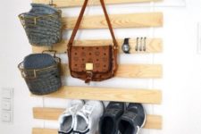 IKEA Luroy slats for an entryway, with metal baskets and hooks for storage and sneakers tacked in