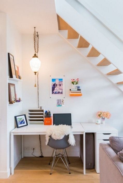 a contemporary working space with a white desk, a comfy chair and some colorful touches right in the living room