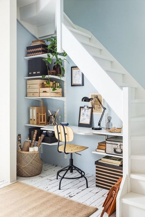 a cute and small home office with an open shelving unit, a floating desk, a wood and metal chair and a basket for storage
