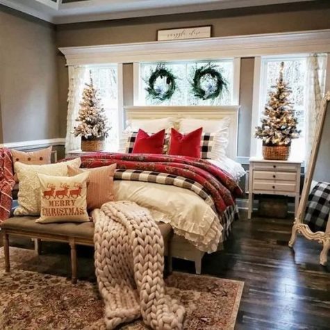 a farmhouse Christmas bedroom with red and buffalo check textiles, a chunky knit blanket, mini snowy trees