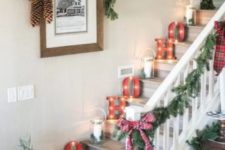 a farmhouse holiday nook with evergreens, plaid bows, pinecones and candle lanterns plus marquee lights