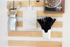 an IKEA Luroy hack for a kitchen with utensil and cutlery holders, a notebook and some planters attached