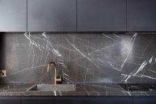 06 a sleek midnight kitchen with blakc strongly veined marble on the backsplash and countertops