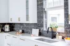 07 an elegant white kitchen with black marble veined tiles that make the cabinetry stand out a lot