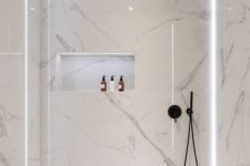 11 a minimalist white bathroom with white marble tiles, a free-standing tub and matte black fixtures